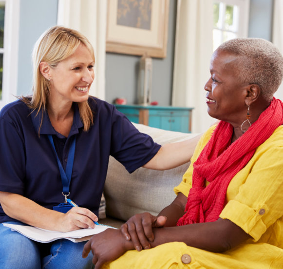 happy caregiver and senior woman talking