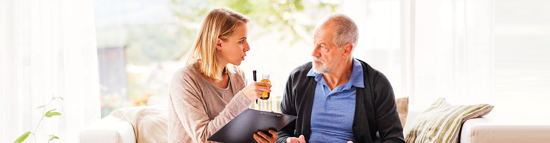 caregiver reminding senior man about his medication