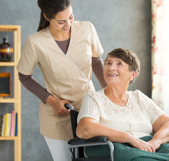 senior woman on wheelchair accompanied by her caregiver