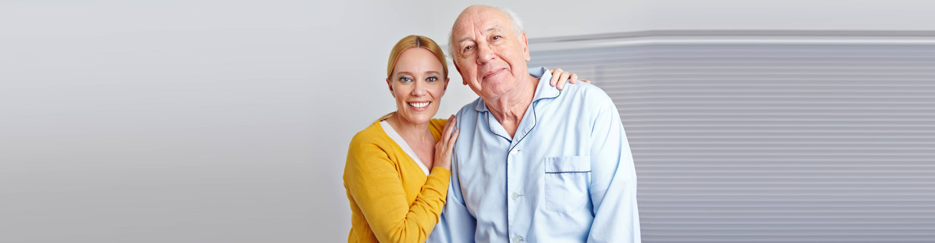 A woman and an old man posing for the camera.