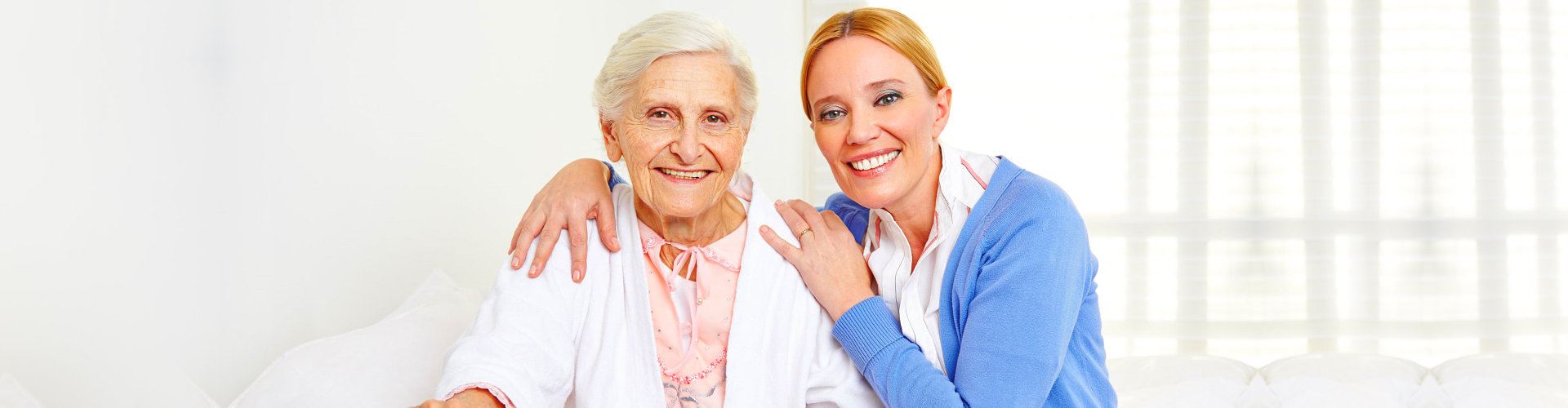 A woman and an old lady smiling for the camera.